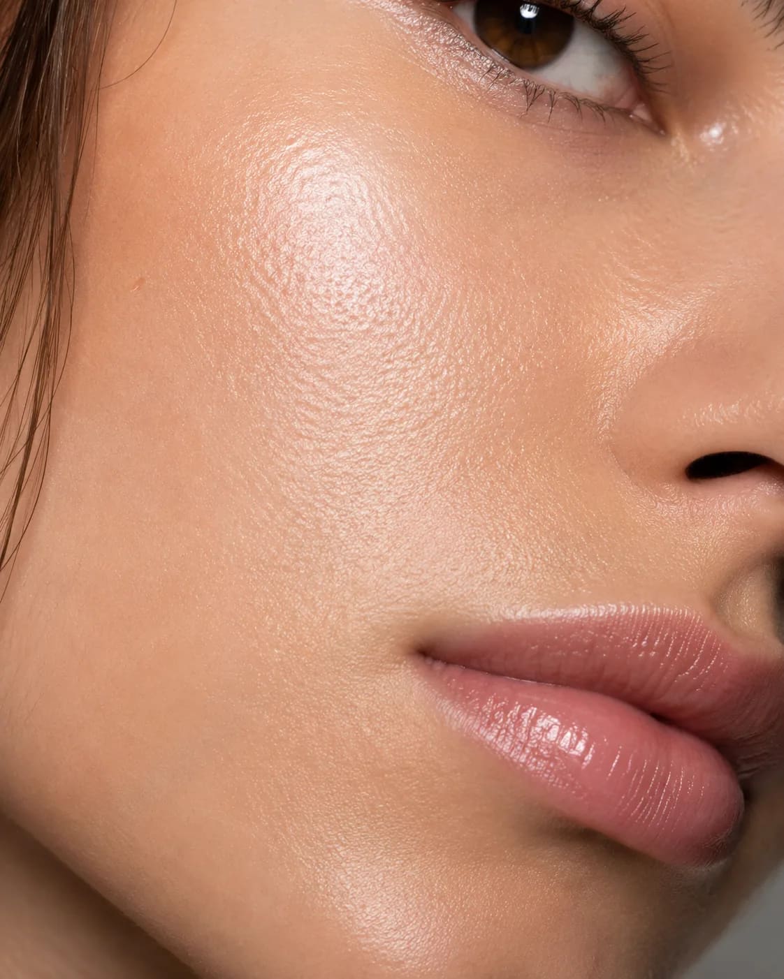 Editorial cheek and lip detail with soft glow and natural proportion